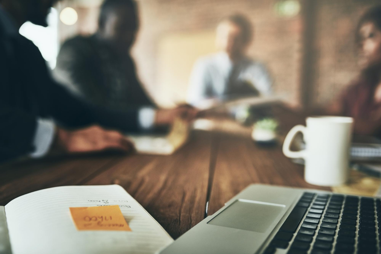 Diverse business team standing around laptop showing analytics dashboard — обсуждение ROI и инвестиций